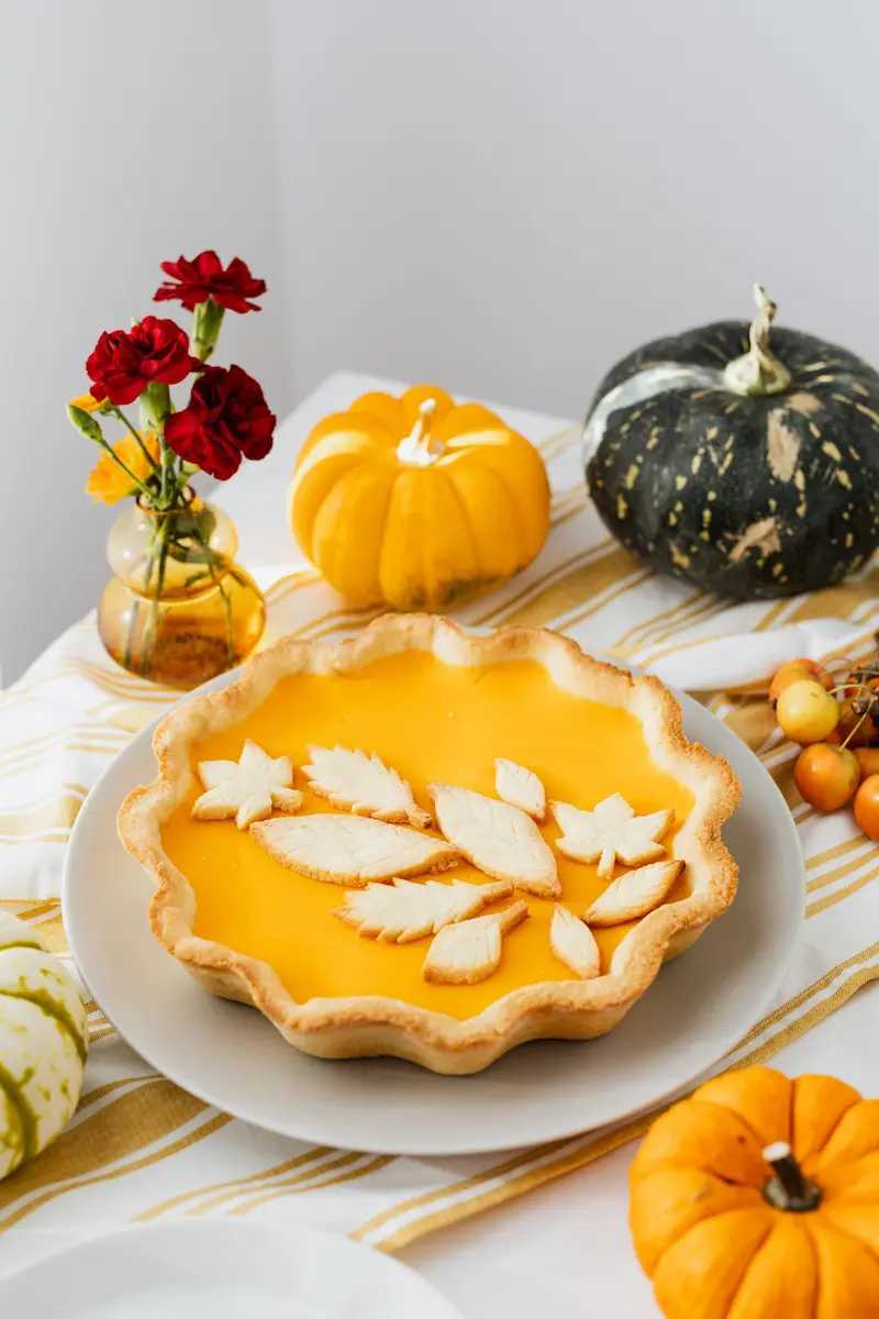 a pie on a plate with flowers and pumpkins